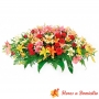 Arreglo de floral para condolencias en forma de ovalo con 24 rosas rojas y 20 varas de Liliums multicolores